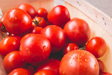 ripe tomatoes in a small wooden crate