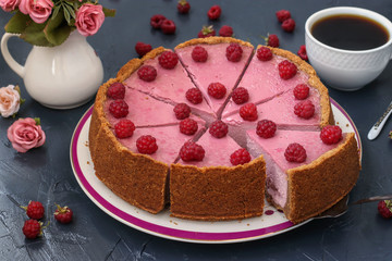 Homemade raspberry cheesecake cut in portions on a plate, located on dark background, Horizontal format