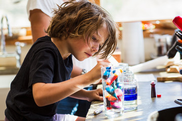 6 year old boy in kitchen with his mother, doing science experiment