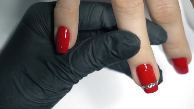 Manicure nail paint red color. Beautiful manicure process.