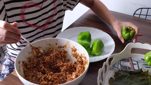 stuffing peppers with home mortar from mother's hands at home