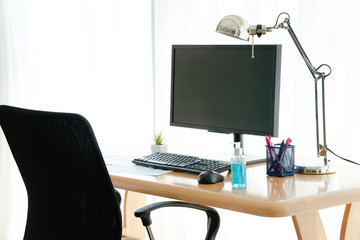 Blue Alcohol gel bottle for Hand wash on desk with office background and copy space - Hygiene and Work from home Concept