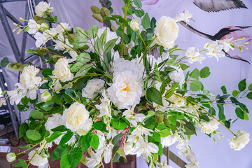 Bouquet of white artificial flowers and green leaves