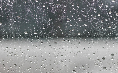 Rain on the surface of the window Stop and flow into the rain. With cloudy backgrounds, natural patterns of isolated raindrops. black and white background.