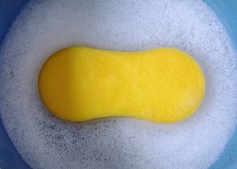 Sponge inside a bucket containing soap
