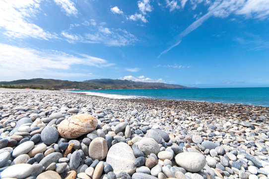 Cretan beach at Kolymvari, saturated. The pebbly beach is in the sun. A light wind blows the vacationers' faces. The island of Crete has many faces.