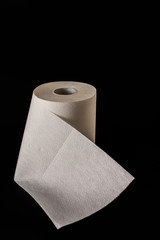 On a black background are a roll of white, kitchen and paper towels. Paper towel.
Copy space. Top view. Flat layout. Minimal background. Isolated.