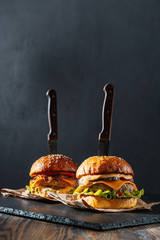 Two mouth-watering, delicious homemade burger used to chop beef. on the wooden table. The burgers...