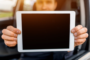 A driver shows a tablet pc screen close-up into the camera. Empty space for your text or graphics.