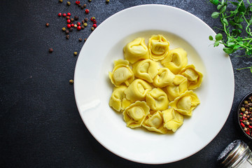 tortellini, pasta with filling (ravioli or dumplings)
second course
Menu concept. food background. top view copy space for text