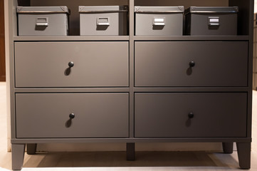Closeup of a gray chest of drawers. A variant of simple furniture without decor and design in the interior.