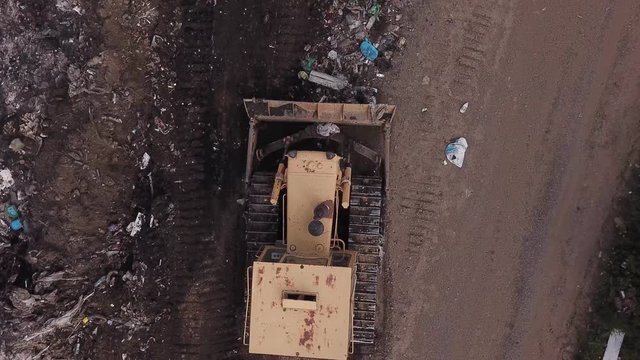 bulldozer collects garbage into a pile