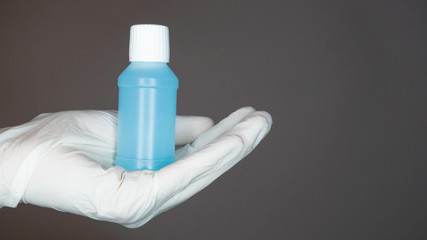 Hand in white glove holding antiseptic blue gel. Concept of medicine health care. Negative space.