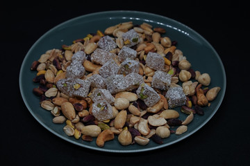 mixed nuts from above. Nuts of granite on a black background. Nuts shot from the top. nuts on a black background. peanut, cashew, roasted chickpea, hazelnut, pistachio, almond, roasted chickpea.