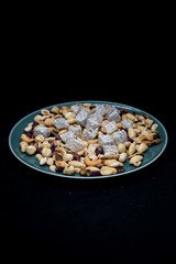 mixed nuts from above. Nuts of granite on a black background. Nuts shot from the top. nuts on a black background. peanut, cashew, roasted chickpea, hazelnut, pistachio, almond, roasted chickpea.