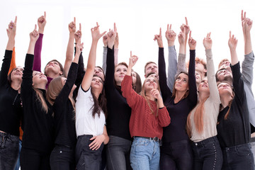 group of diverse young people pointing up