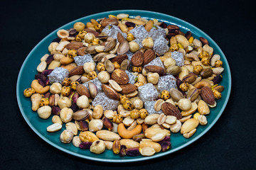 mixed nuts from above. Nuts of granite on a black background. Nuts shot from the top. nuts on a black background. peanut, cashew, roasted chickpea, hazelnut, pistachio, almond, roasted chickpea.