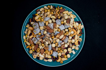 Obraz na płótnie Canvas mixed nuts from above. Nuts of granite on a black background. Nuts shot from the top. nuts on a black background. peanut, cashew, roasted chickpea, hazelnut, pistachio, almond, roasted chickpea.