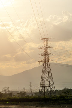 The high voltage pole in the afternoon and evining with the mountain background and cloudy sky.