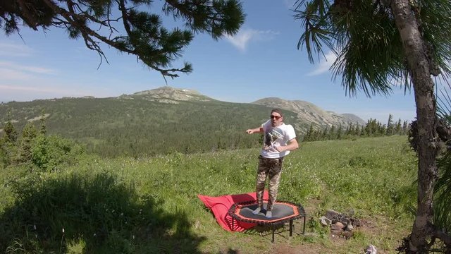 a young man jumps on a trampoline