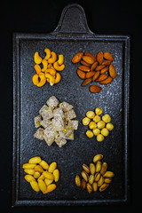 Fototapeta na wymiar mixed nuts from above. Nuts of granite on a black background. Nuts shot from the top. nuts on a black background. peanut, cashew, roasted chickpea, hazelnut, pistachio, almond, roasted chickpea.