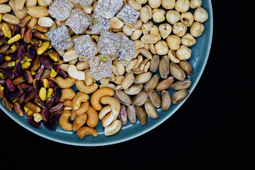 mixed nuts from above. Nuts of granite on a black background. Nuts shot from the top. nuts on a black background. peanut, cashew, roasted chickpea, hazelnut, pistachio, almond, roasted chickpea.
