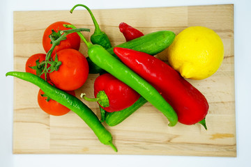 salad content top view. Fresh vegetables on wooden cutting board. salad ingredients. healthy foods. paprika, cucumber, green pepper, lemon, tomato for salad.
