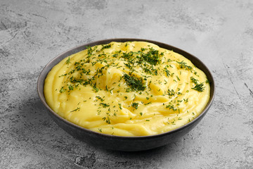 Ceramic plate with mashed potato on abstract concrete background