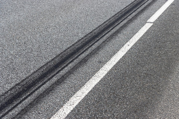 Fototapeta premium A burned rubber tire track on an asphalt road.