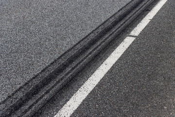 Fototapeta premium A burned rubber tire track on an asphalt road.