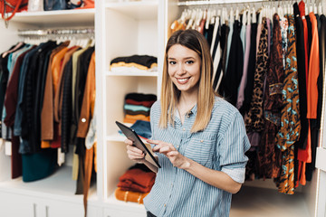 Beautiful female seller working in exclusive boutique or store.