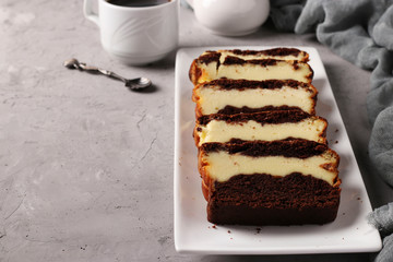Sliced homemade chocolate muffin with cottage cheese located on a white plate on gray background, Closeup, Copy space