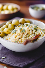 Bulgur with green olives and pepitas, healthy nutrition easy recipe from long-stored food.