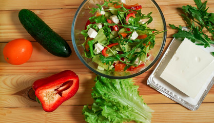 Fresh vegetables and cheese salad on a wooden table
