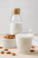 Almond milk in a glass and a glass bottle.
