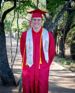 Young, attractive boy with red hair taking graduation pictures