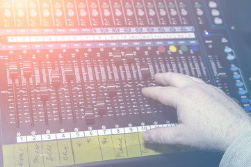 Human hand on the mixing console in the recording Studio. Spotlight.