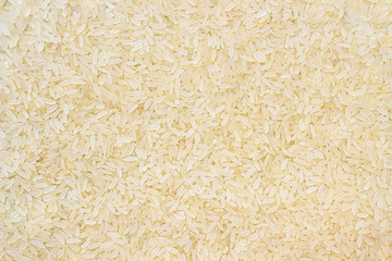 Layer of rice grits. Food background of long-grain rice.