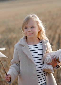 Little towheaded girl holding a teddy hair on her walk