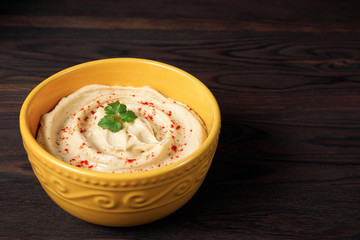 Plate of traditional chickpea hummus on a wooden background
