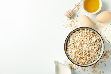 Composition with oatmeal flakes on white background, top view. Cooking breakfast