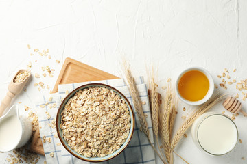 Composition with oatmeal flakes on white background, top view. Cooking breakfast