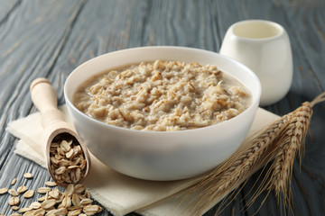 Composition with oatmeal porridge on wooden background. Cooking breakfast