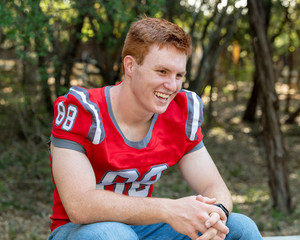 Fototapeta premium Young, attractive boy with red hair taking graduation pictures