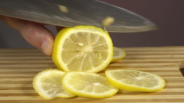 Chop the lemon with a knife. Health food. Close-up. Macro. On a red background