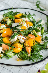 Fresh salad with arugula, mango, papaya, mozzarella, passion fruit and pine nuts.