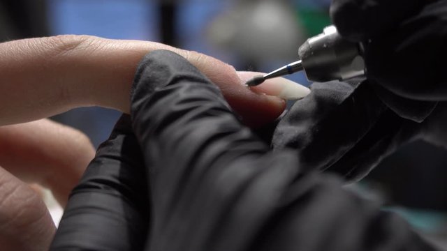 beautician making hardware manicure. woman hands receiving nail procedure in beauty salon
