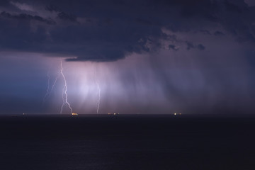 Fototapeta na wymiar beautiful lightning in the sea, thunderclouds with lightning, lightning discharges