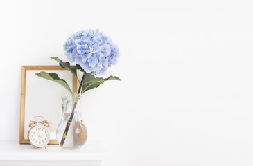 Blue hortensia flowers in the vase with wooden frame in provence interior.