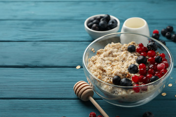 Bowl with oatmeal porridge and fruits on wooden background. Cooking breakfast